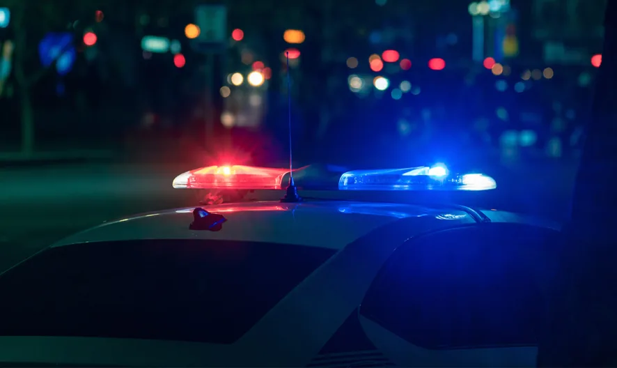 Image of the top of a police care with it's lights flashing