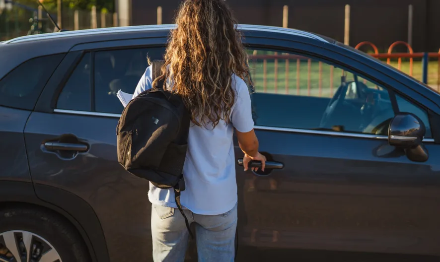A woman starting to open a car door.